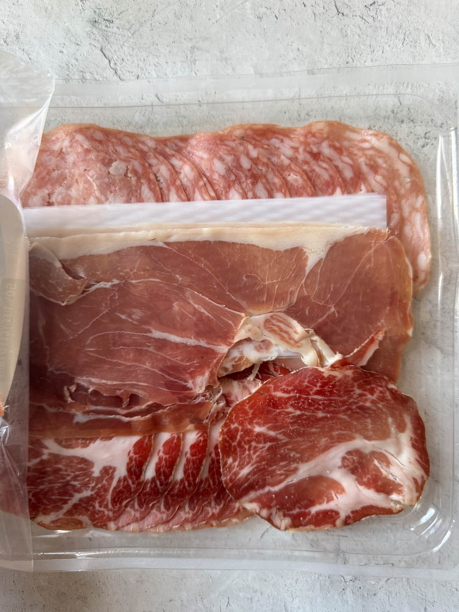 different types of sliced meat in the plastic tray