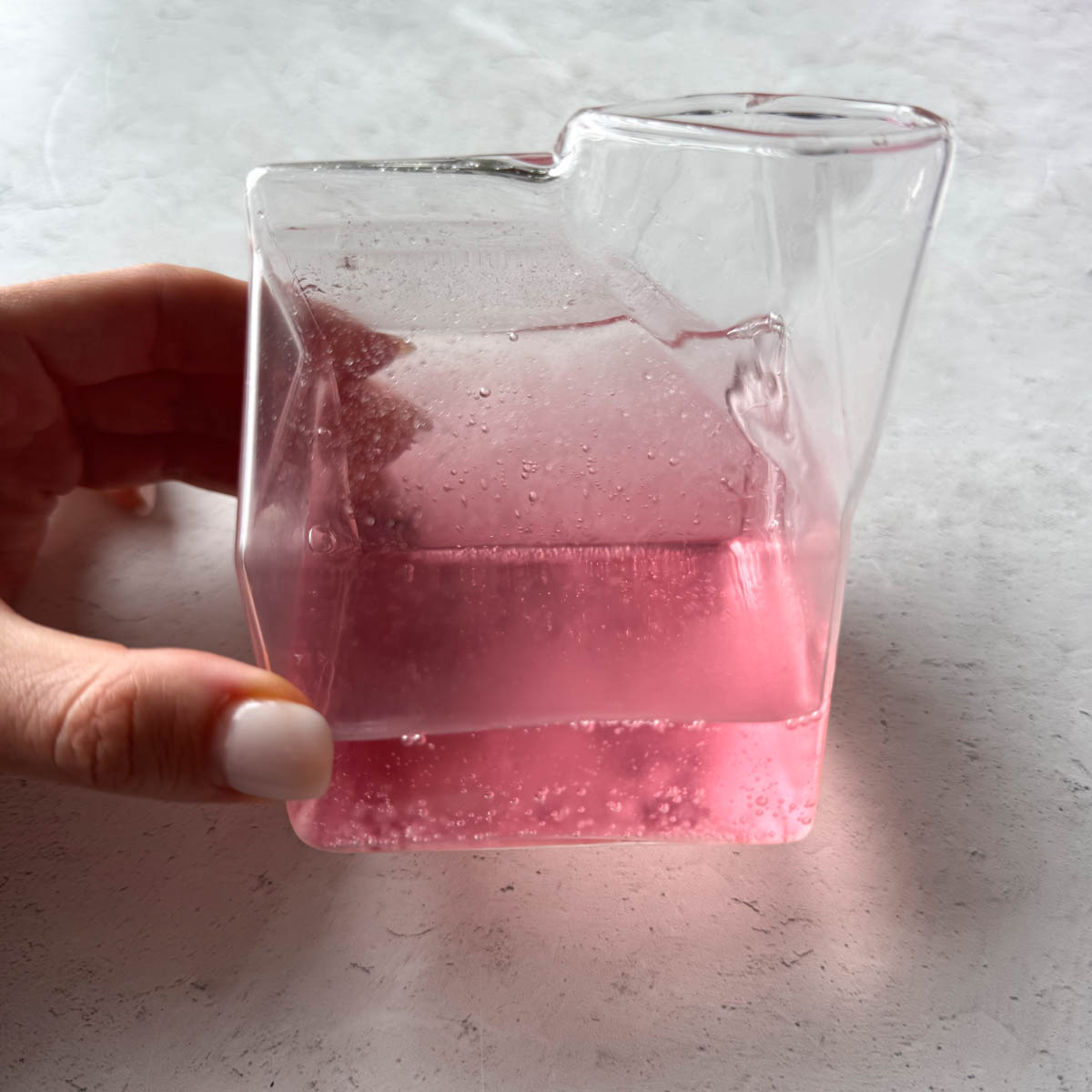 a glass full of coconut water pink in color