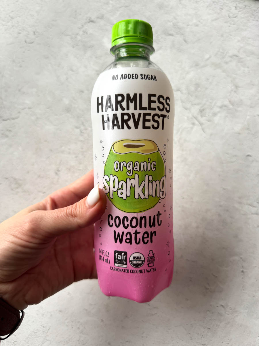 a bottle of coconut water in hand