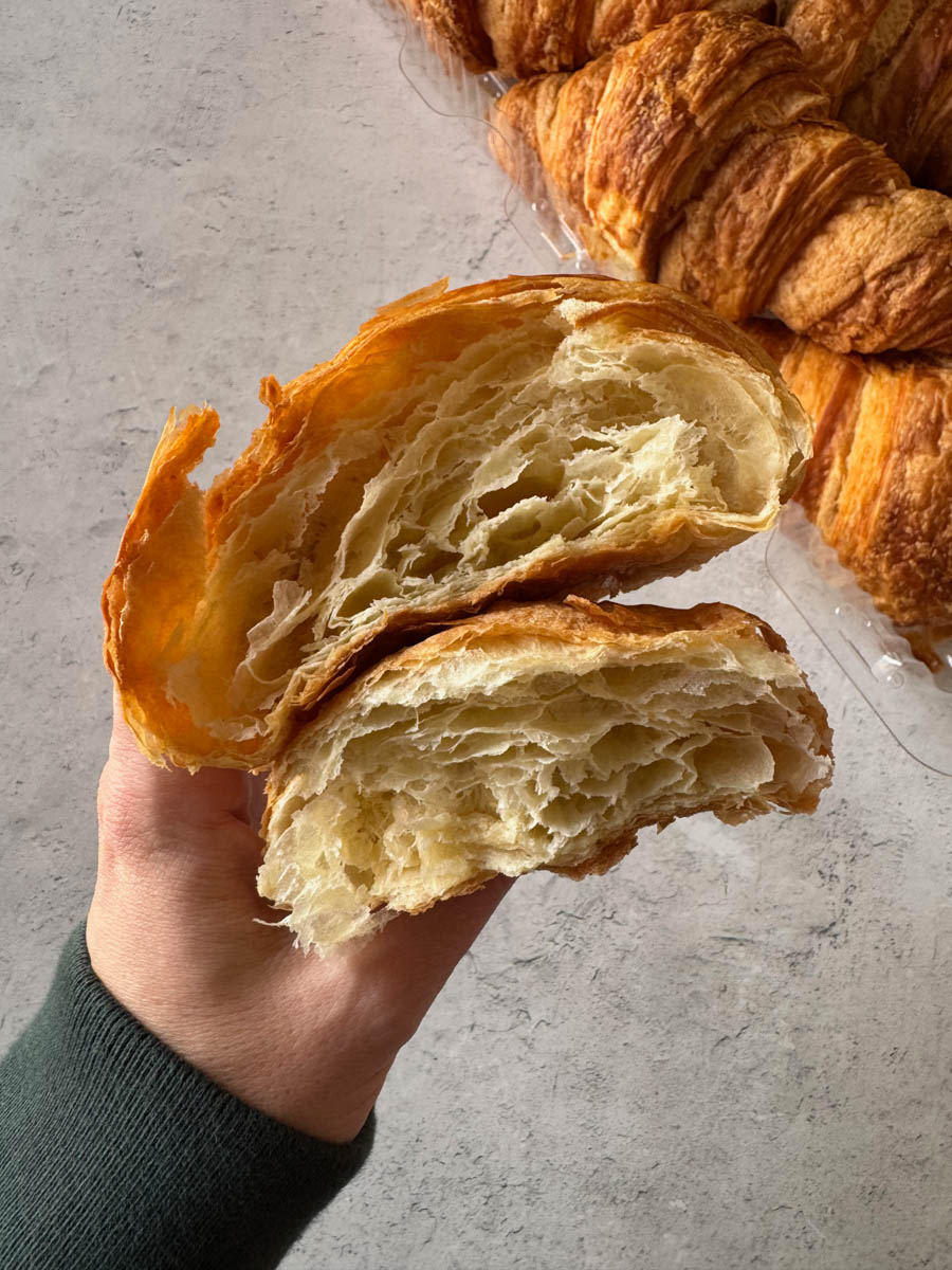costco croissant cut in half in hand
