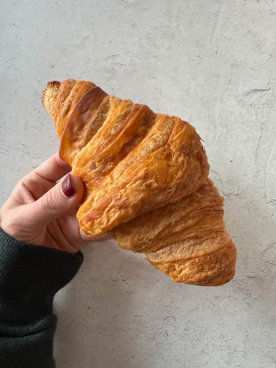 holding a croissant in hand