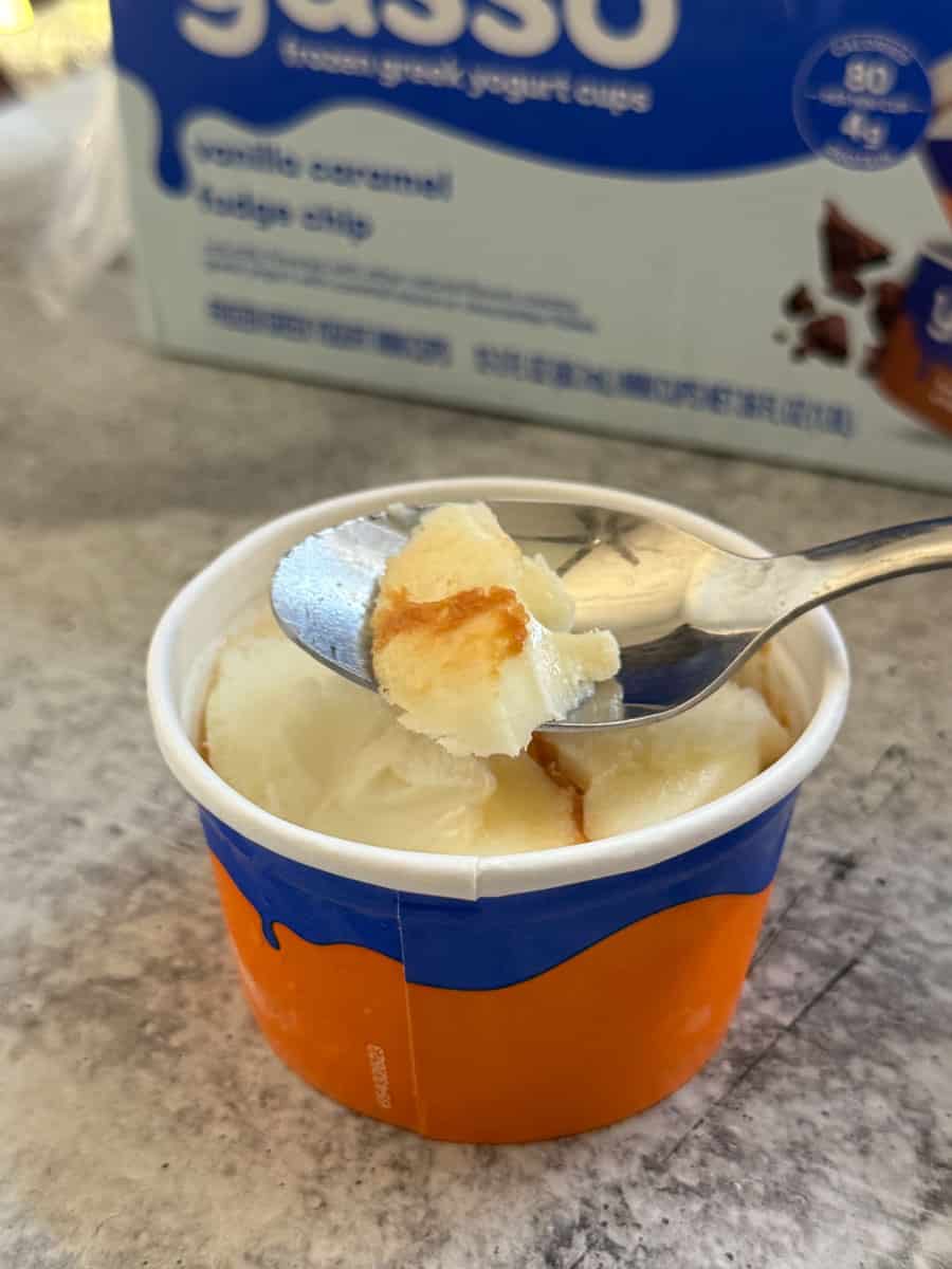 Creamy vanilla ice cream in a blue and orange cup with a spoon, perfect for a sweet treat.