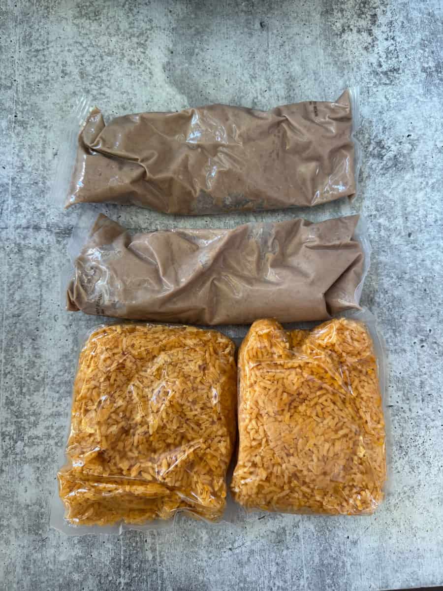 Frozen homemade burritos and rice packs on a textured surface.