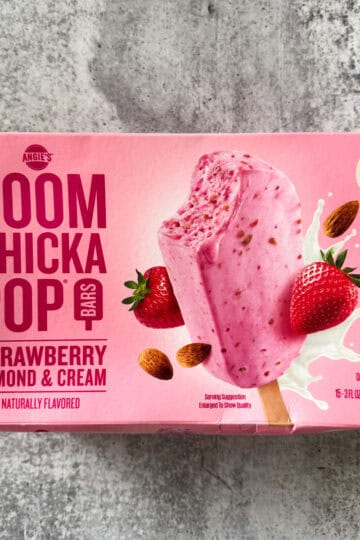 Strawberry almond & cream ice bar with strawberries and almonds on pink packaging.