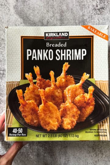 Frozen breaded panko shrimp on black plate, perfect for quick meals.