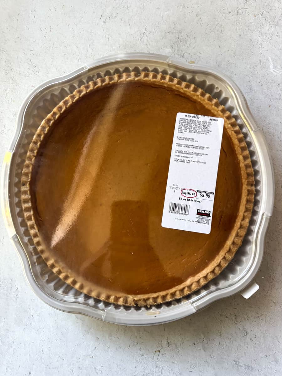 Costco pumpkin pie in clear plastic container with label for sale.