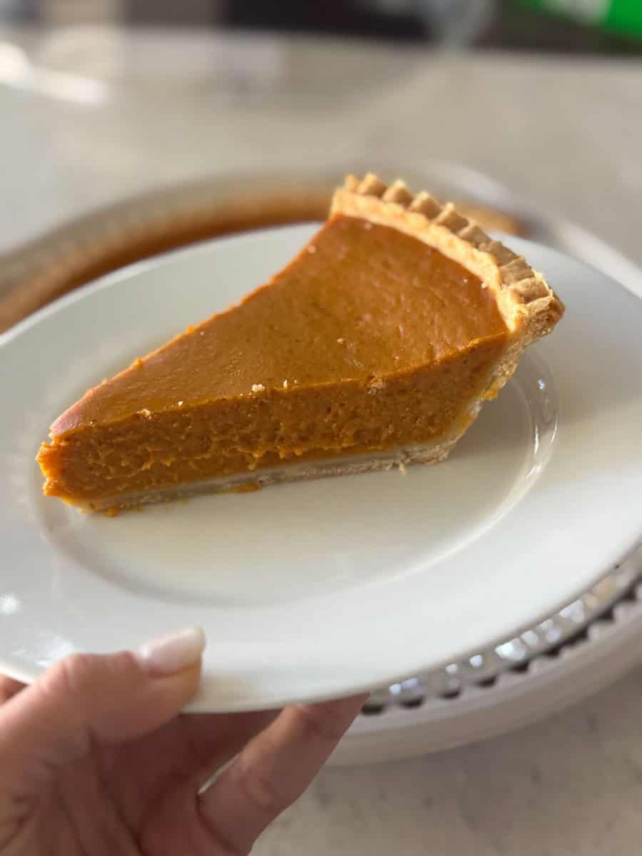 Delicious pumpkin pie on a white plate from Costco.