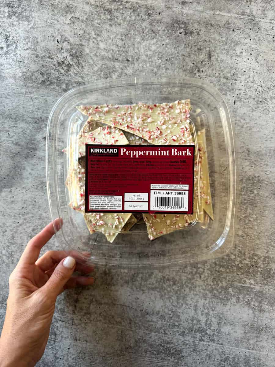 Kirkland Peppermint Bark in clear plastic container on gray surface.