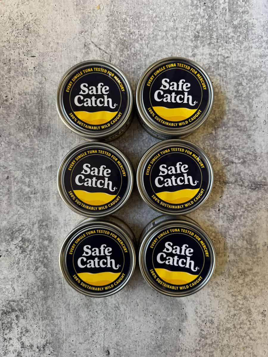 Safe Catch certified tuna cans arranged on a textured surface.