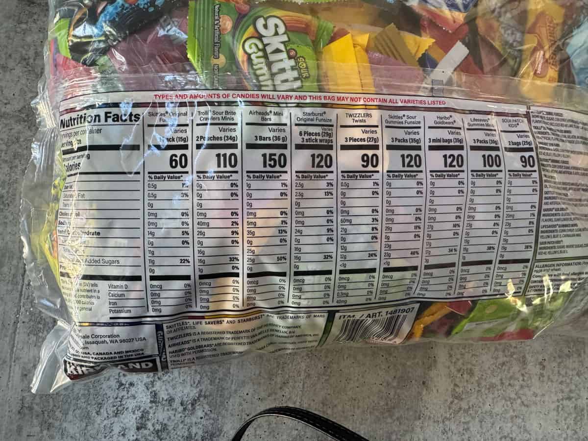 Assorted candies in a clear bag showing nutrition facts label and colorful wrappers.